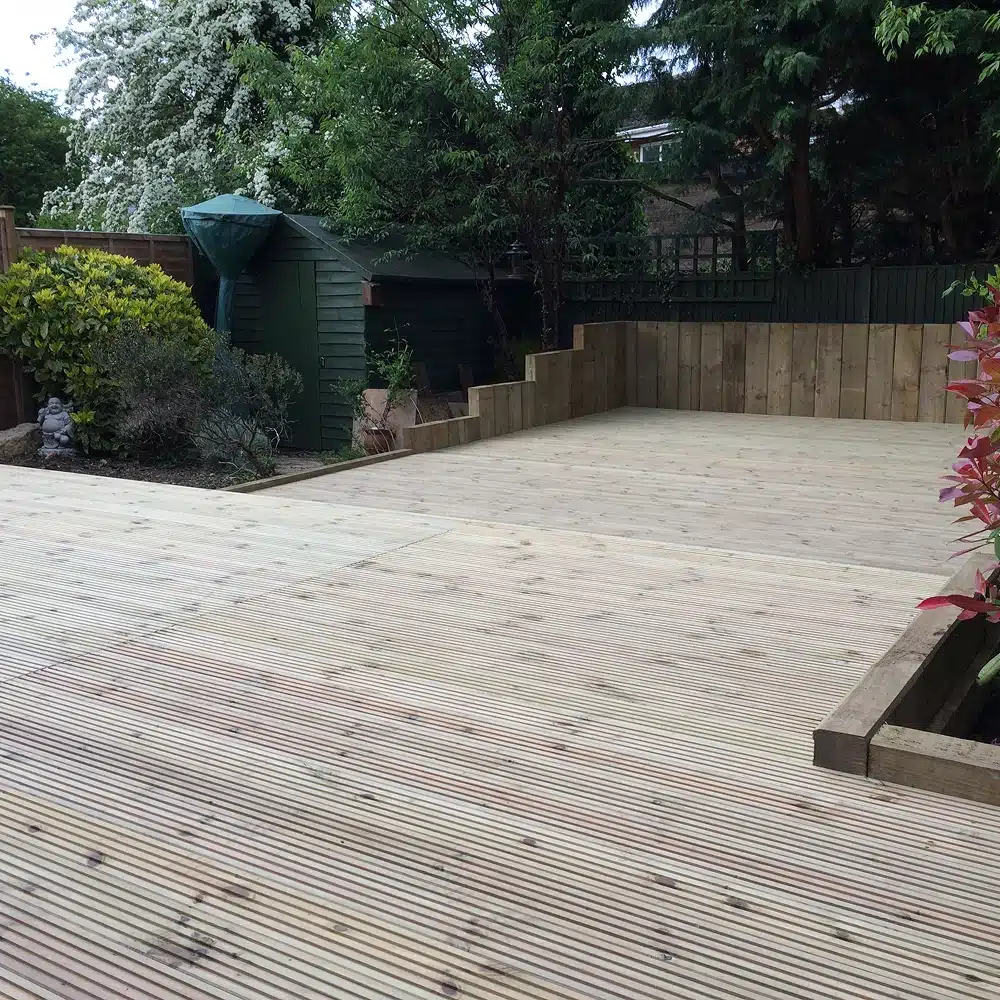 Newly built wooden garden deck with raised planters and surrounding trees