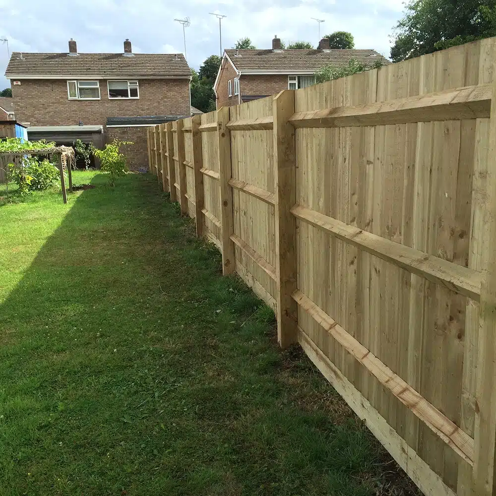 New wooden garden fence along the side of a lawn
