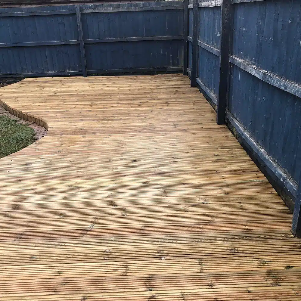 Wooden decked patio beside a dark blue fence