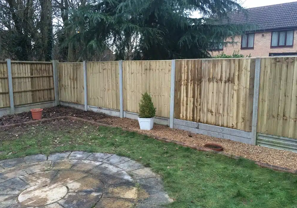 Back garden with wooden fence, lawn and patio area