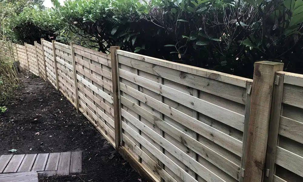 New wooden slatted fence along a garden boundary