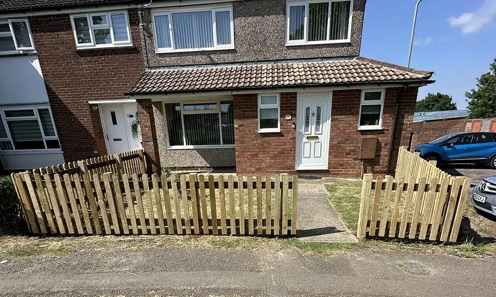 Semi-detached house with a small front garden and wooden picket fence